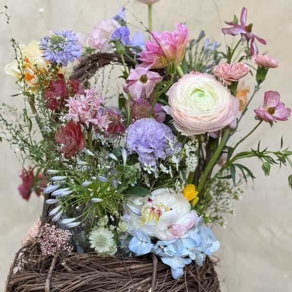 Mixed pastel flower arrangement in a woven basket