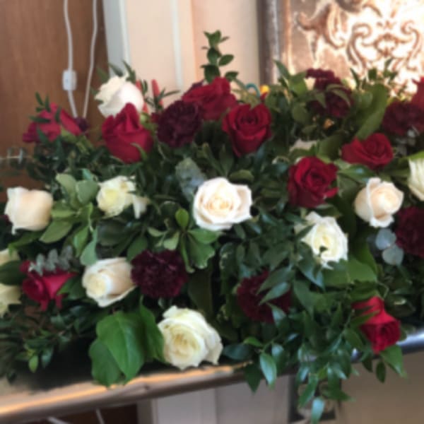 Large arrangement of red and white roses on a table