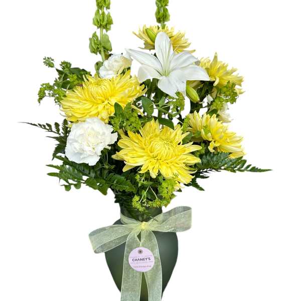 Yellow and white floral arrangement in a dark vase with a ribbon