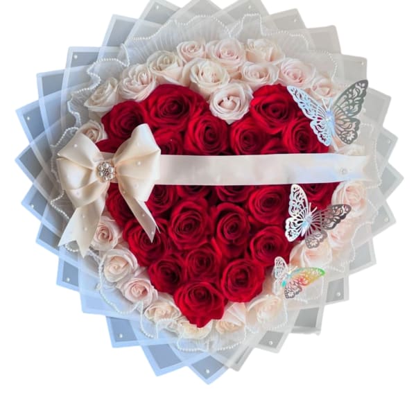 Heart-shaped bouquet of red and pale pink roses with a ribbon bow