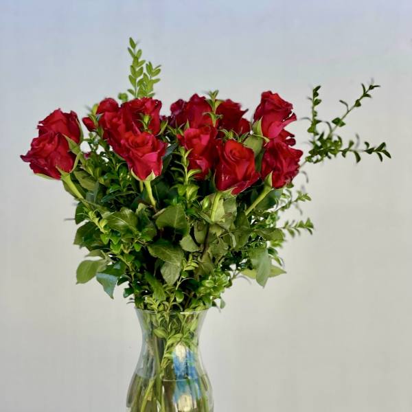 Red roses arranged in a clear glass vase