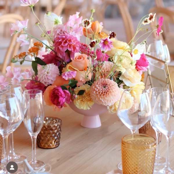 Pastel floral centerpiece in a pink vase on a table