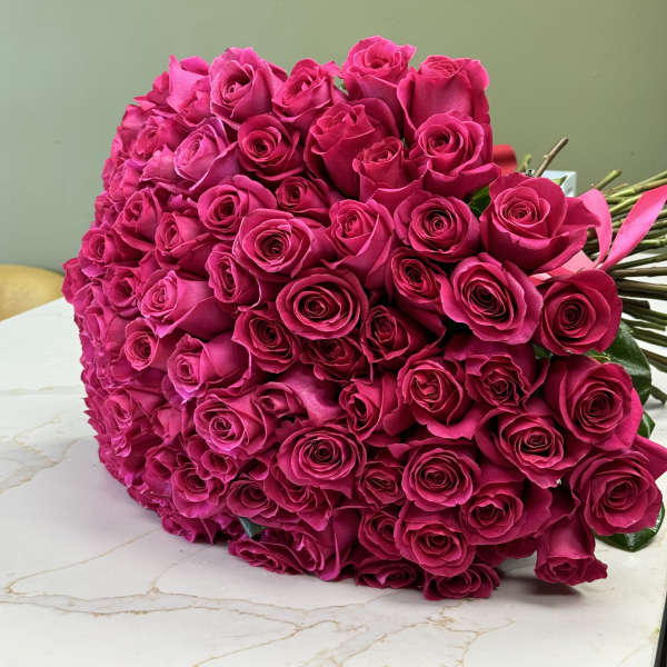 Large bouquet of bright pink roses on a tabletop