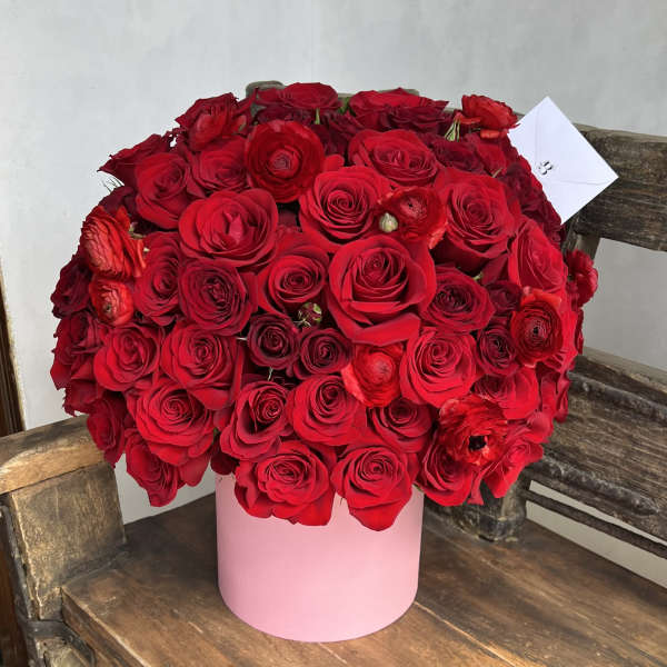 Large bouquet of red roses in a pink cylindrical box