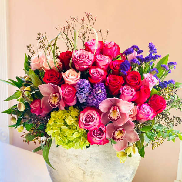 Mixed pink and purple floral arrangement in a silver vase