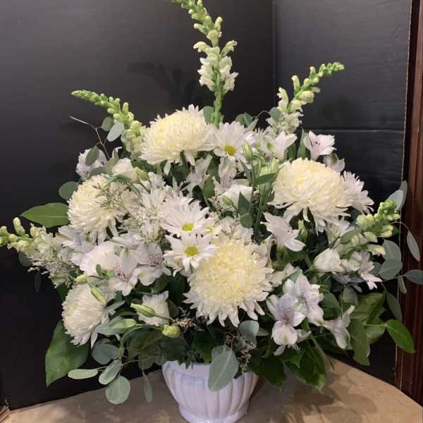White floral arrangement in a white ceramic vase