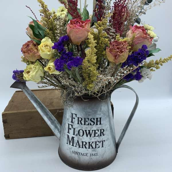 Dried flower arrangement in a metal watering can