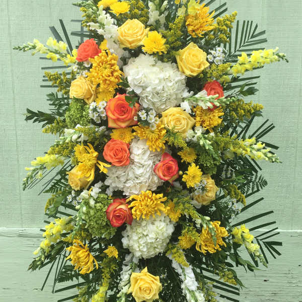 Standing floral spray with yellow, white, and orange blooms