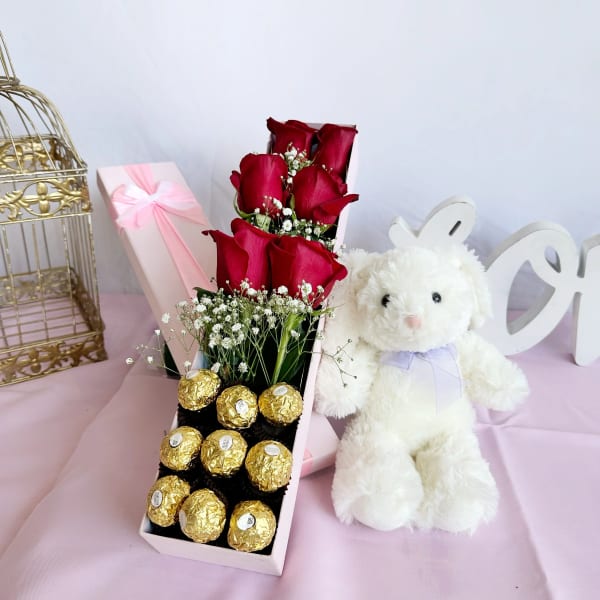 Red roses in a gift box with chocolates and a white teddy bear