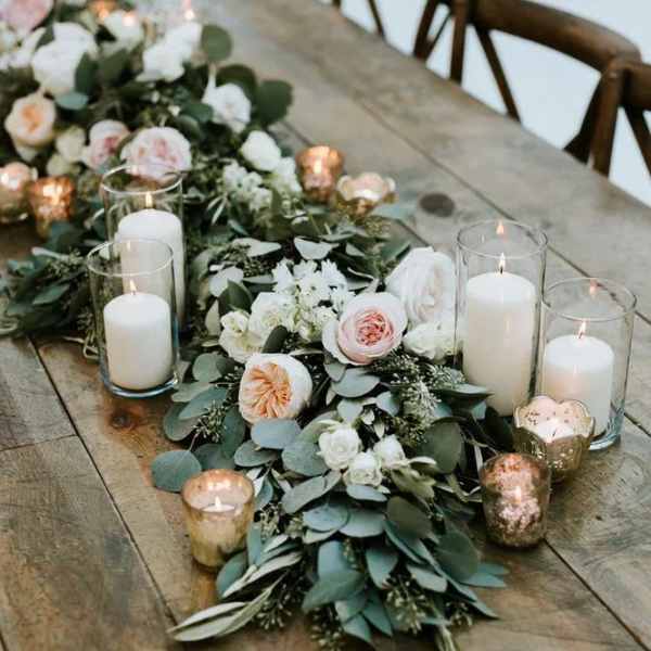 Floral table runner with white and blush blooms and glass candles
