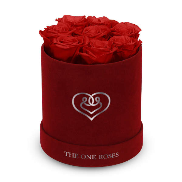 Red roses arranged in a round velvet box with a heart logo