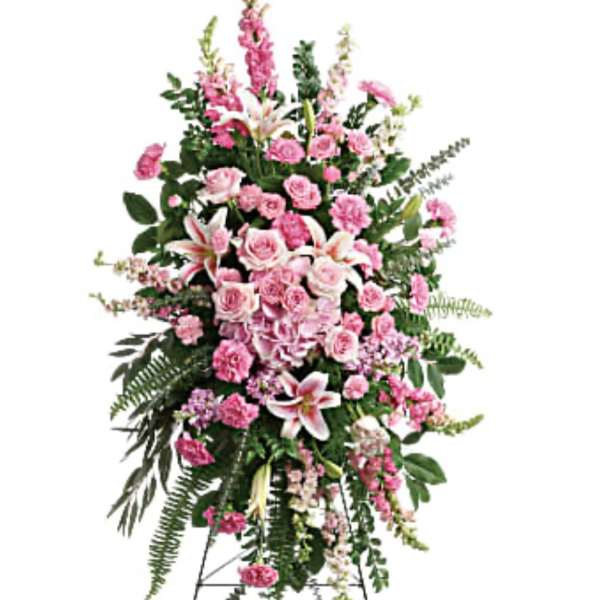 Tall pink funeral spray on a stand with lilies and roses