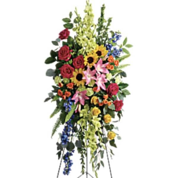 Tall standing floral spray with mixed colorful blooms on an easel