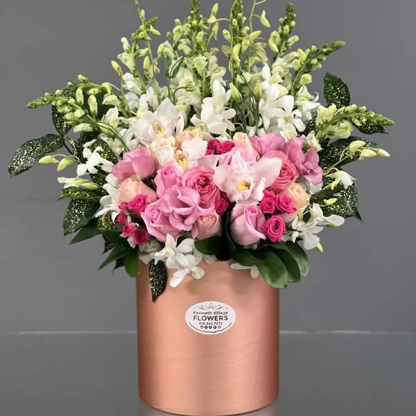 Pink and white floral arrangement in a rose-gold cylindrical box