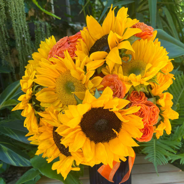 Sunflower and orange rose bouquet in a black vase