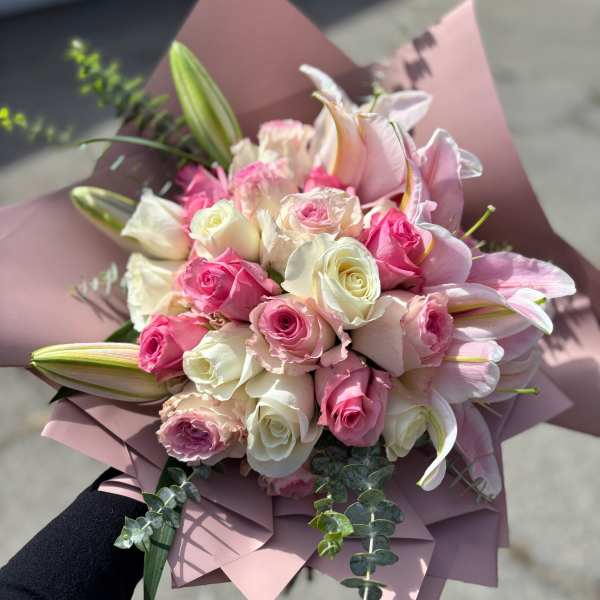 Pink and white rose bouquet with lilies wrapped in pink paper
