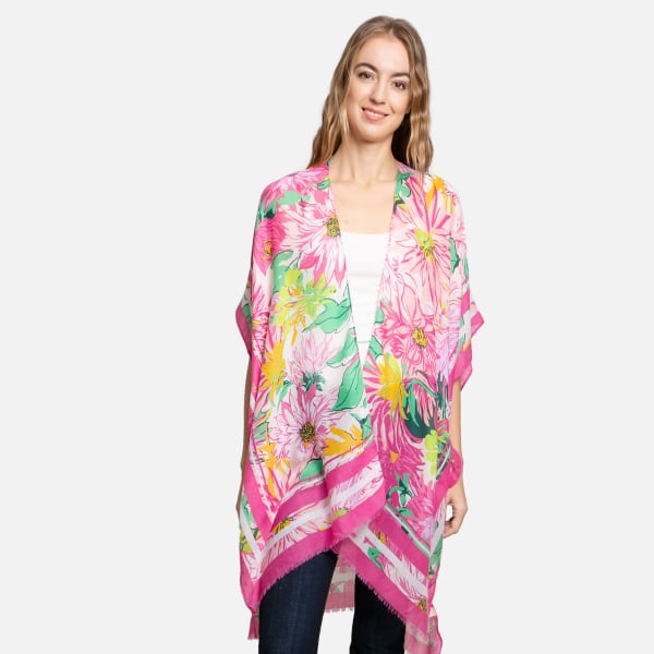 Woman wearing a bright pink floral kimono wrap over jeans and a white top