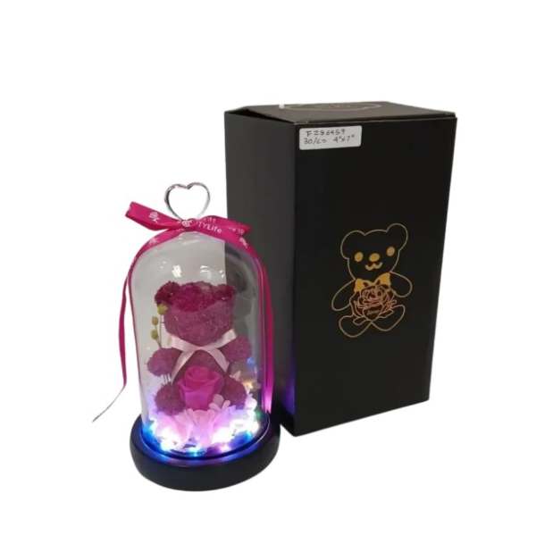 Pink teddy bear and artificial rose under glass dome with lights beside black gift box