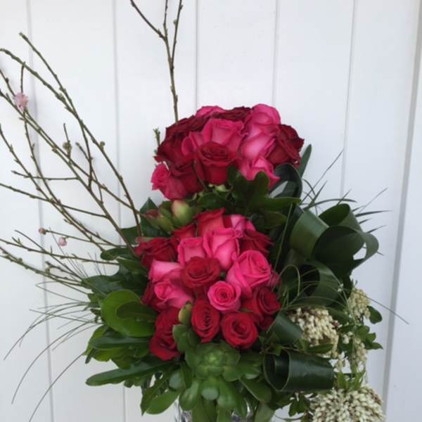 Pink and red rose arrangement in a patterned vase