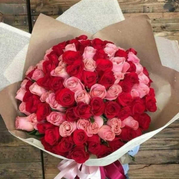Large bouquet of red and pink roses wrapped in brown paper