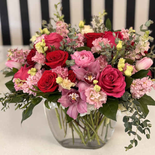 Mixed pink and red flower bouquet in a clear glass vase