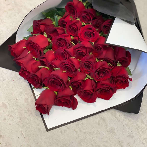 Bouquet of red roses wrapped in black and white paper