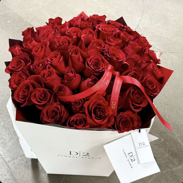 Large bouquet of red roses in a white box with a red ribbon