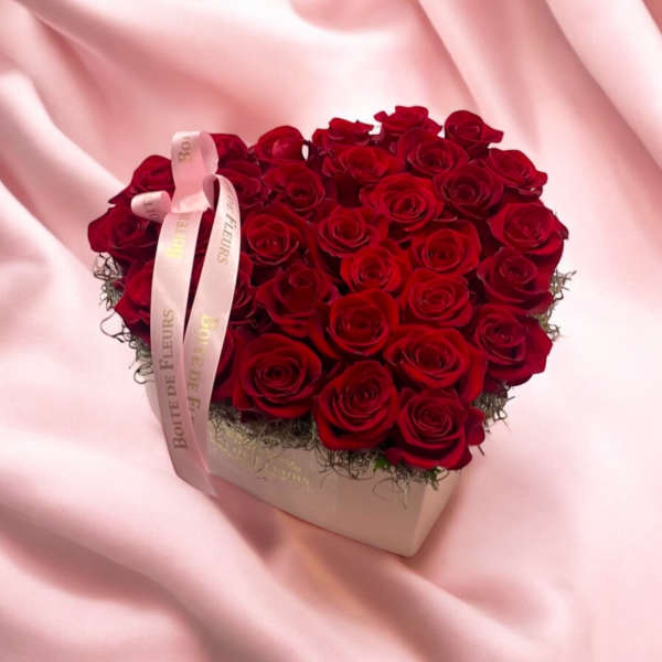 Heart-shaped box of red roses with a pink ribbon