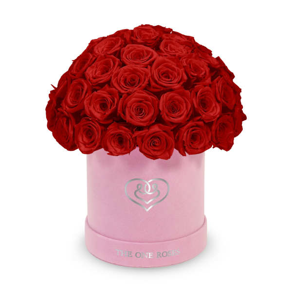 Red roses arranged in a pink round box with a heart logo
