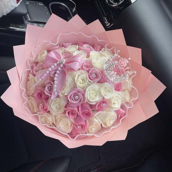 Pink and white rose bouquet wrapped in pink paper with pearl trim