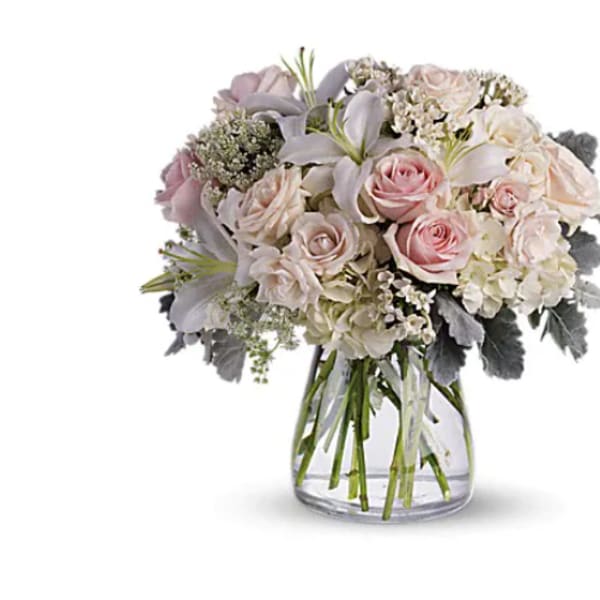 Bouquet of pale pink and white flowers in a clear glass vase