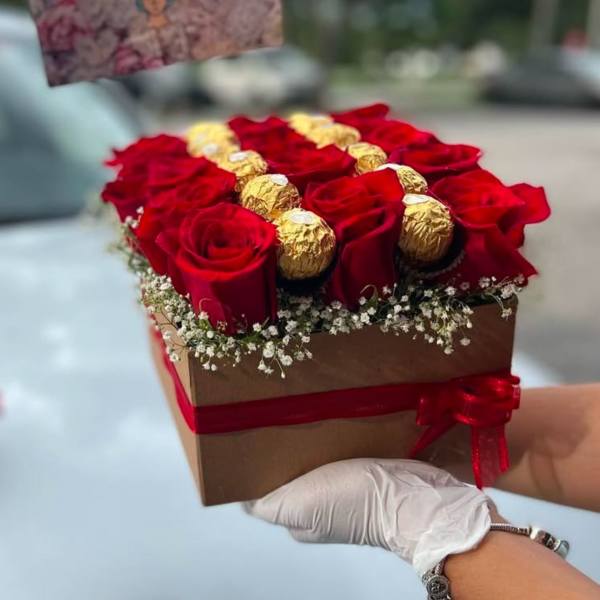 Red roses and gold-wrapped chocolates in a square gift box