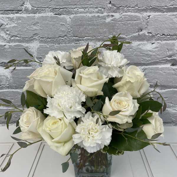 White rose and carnation bouquet in a square glass vase