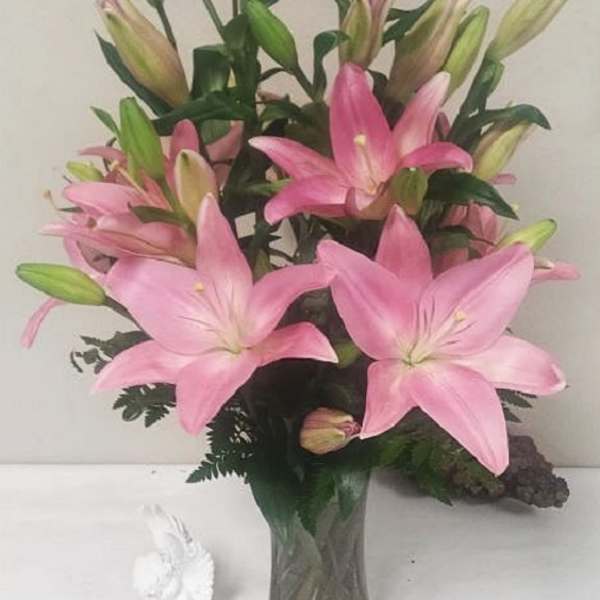 Pink lilies arranged in a clear glass vase