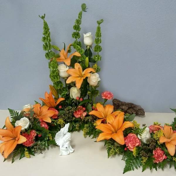 Orange lilies and white roses arranged in a floral display