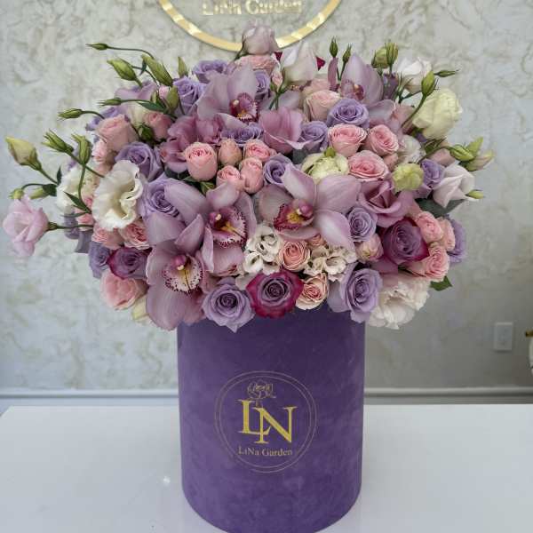Large pastel bouquet of pink and lavender flowers in a purple box