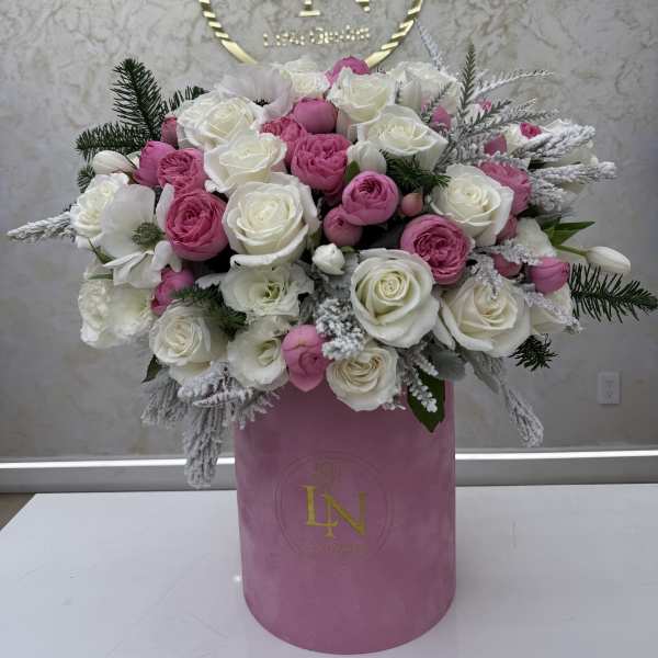 Pink and white rose arrangement in a pink hat box