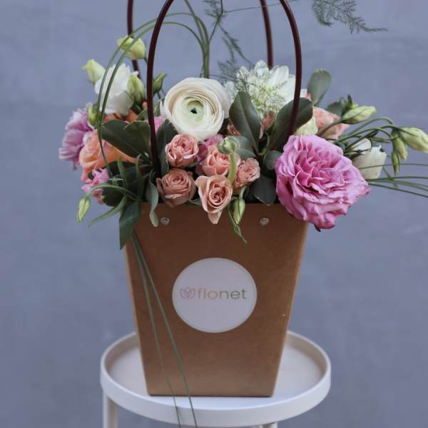 Basket arrangement with pink and white flowers and tall looping stems