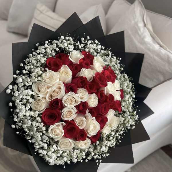 Bouquet of red and white roses wrapped in black paper