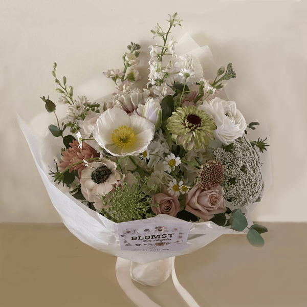 Bouquet of pastel flowers wrapped in white paper