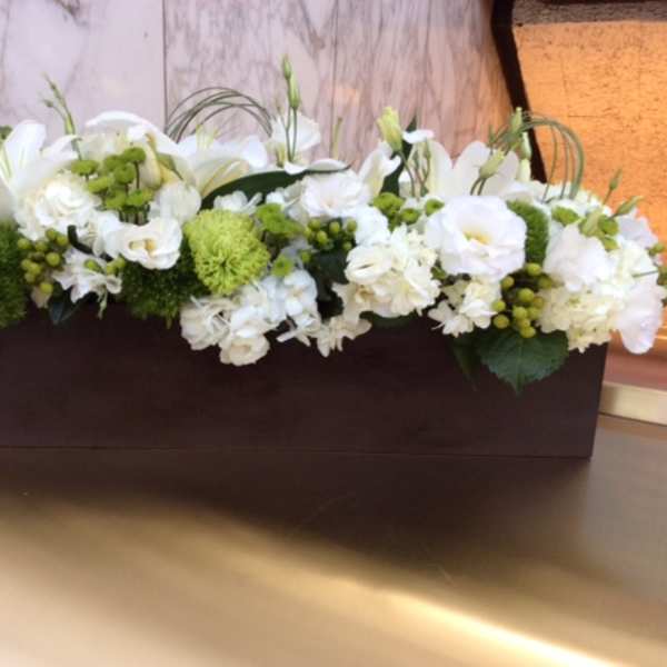 White floral arrangement in a rectangular brown container