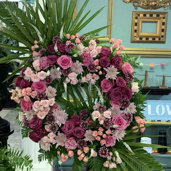 Large pink and purple floral wreath with palm fronds