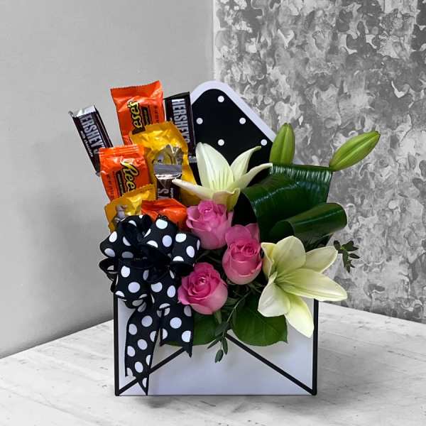 Candy bouquet with pink roses and white lilies in a black-and-white polka dot box
