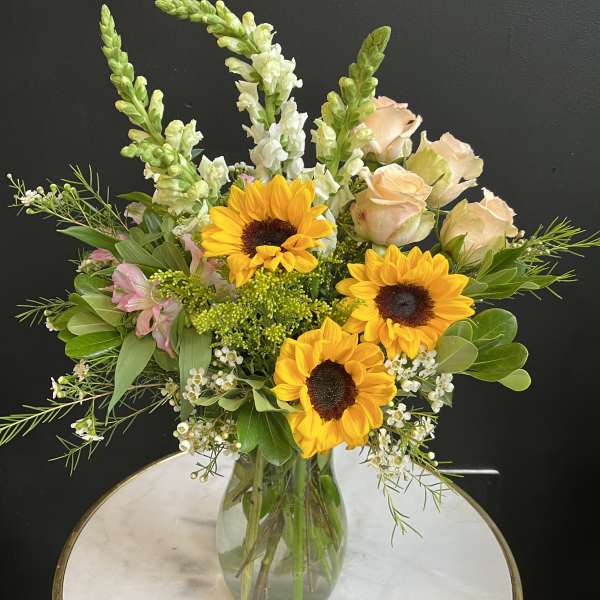 Sunflowers and pale roses in a glass vase