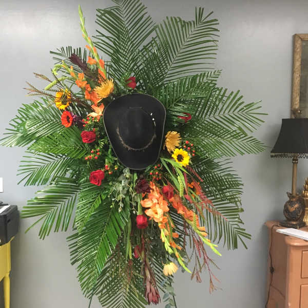 Large floral display with a black cowboy hat in the center