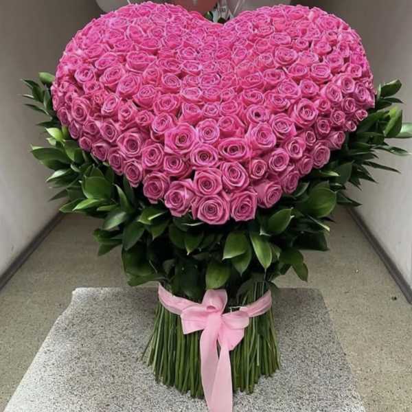 Heart-shaped bouquet of pink roses with a pink ribbon