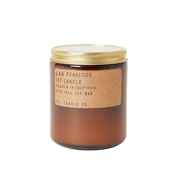 Amber soy candle in a glass jar with a gold lid and label