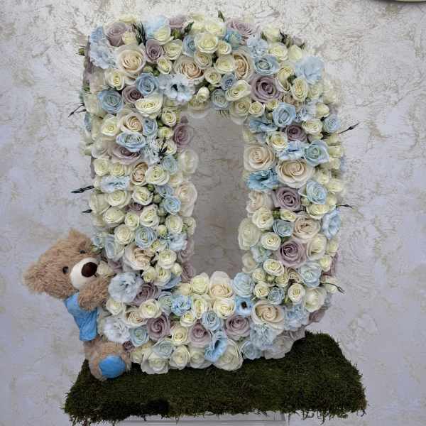 Large floral letter U with a teddy bear at the side