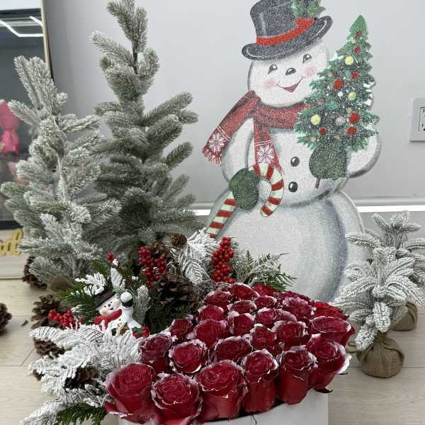 Red roses in a white hatbox with Christmas decorations