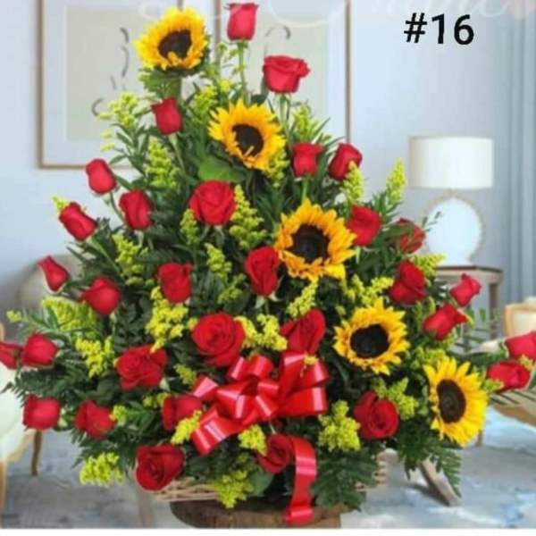 Large arrangement of red roses and sunflowers with a red ribbon bow